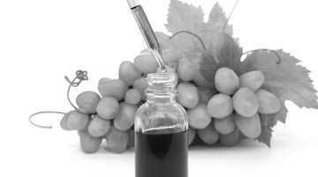 Dropper bottle with grapeseed oil and fresh grape bunch in the background, highlighting natural ingredients for beard care.