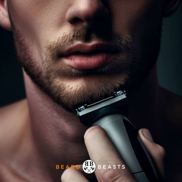 Man precisely trimming his short beard with an electric trimmer, demonstrating how to trim a short beard.
