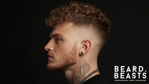 Side profile of a man showcasing one of the best Short Curly Hairstyles for Men, featuring voluminous, textured curls on top and a sharp skin fade on the sides.