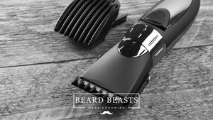 A black hair clipper with a shiny finish and an attachment comb alongside a fine-toothed comb on a rustic wooden background, representing materials for the guide on how to clean hair clippers by Beard Beasts Men's Grooming.