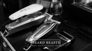 An array of professional hair clippers and accessories on a barbershop work station for the article How Do Clipper Guards Work.