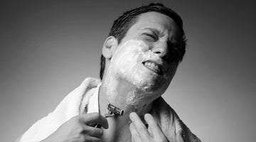 Man experiencing razor burn while shaving with foam