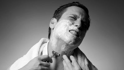 Man experiencing razor burn while shaving with foam