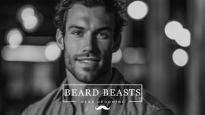 A black and white promotional image featuring a smiling man with a well-maintained stubble beard, exemplifying the modern, approachable look that Beard Beasts Men's Grooming advocates for those learning how to grow stubble