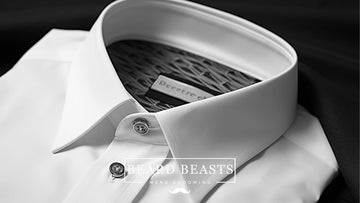  Elegantly tailored white dress shirt on a dark background, showcasing the ideal fit and design, embodying the principles of how should a dress shirt fit