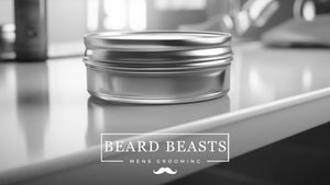 A tin of men's grooming hair clay on a sleek countertop with a blurred background, featuring the "Beard Beasts" brand logo, representing a product in the hair clay vs wax category for styling.