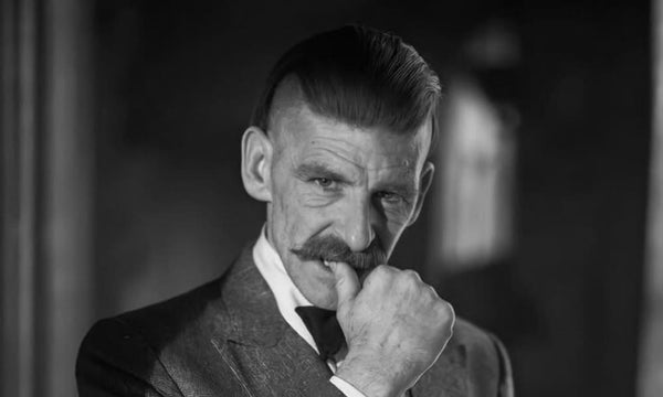Arthur Shelby haircut featuring a disconnected undercut with slicked-back top and shaved sides, styled with vintage Peaky Blinders flair.