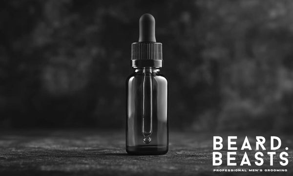 Beard oil bottle with dropper on a dark surface, featured image for article answering the question: is beard oil necessary?