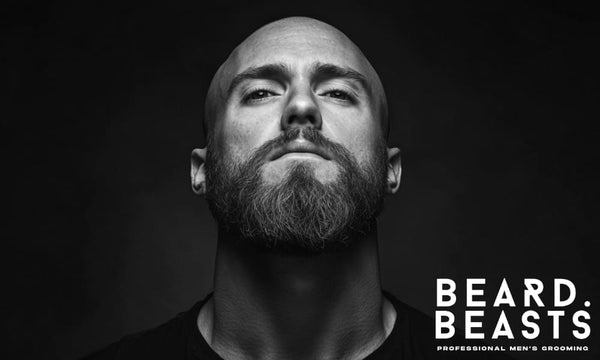 Close-up of a bald man with a full ginger beard looking confident—featured image for beard styles for bald guys.