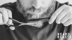 Close-up of man trimming beard with scissors and comb, highlighting common beard trimming mistakes and grooming tips