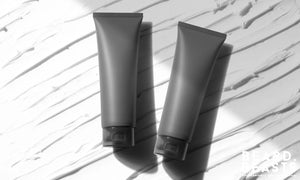 Two sleek grey hair gel tubes on a white textured background — representing the best hair gels for men in 2025.