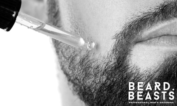 Close-up of beard oil being applied with a dropper to facial hair, visually addressing the question—does beard oil work for growth and conditioning?
