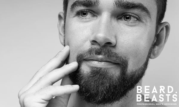 Close-up of a man touching his beard, highlighting dry skin under beard and facial grooming concerns