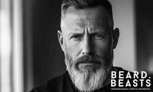 Black and white portrait of a 50-year-old man with a full grey beard and short haircut, representing timeless and masculine beard styles for older men.