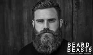 Confident man with a thick, full Garibaldi beard and styled red hair—showcasing the classic rounded beard shape with a bold, natural look.