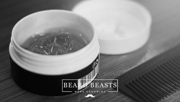 A black and white photo of an open container of hair pomade, next to a closed container and a fine-toothed comb, contrasting pomade vs paste for hair styling
