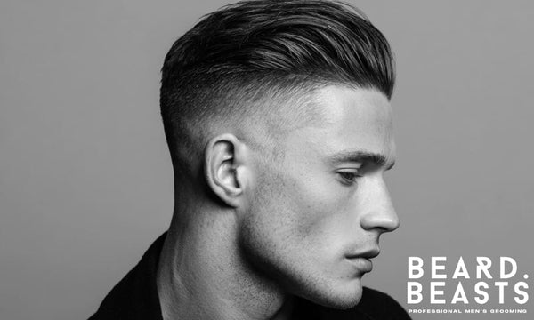 Black and white profile of a man with a high fade slick back haircut—clean sides, voluminous top, and structured finish.