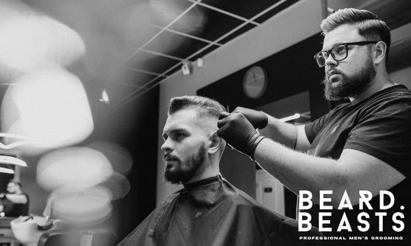 How to find a good barber shop—barber giving a clean modern haircut to a bearded man in a stylish barbershop.
