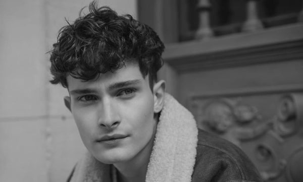Man with messy textured hairstyle looking confident, showcasing how to style men’s hair messy with volume and natural texture.