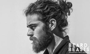 Side profile of a rugged man with a textured man bun and beard, showcasing natural volume, clean grooming, and a bold masculine look.