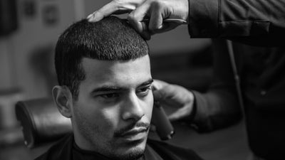 Man receiving a precise #6 buzz cut in a barber shop, showcasing the stylish and clean look of the haircut.