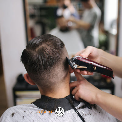 a man getting a haircut pondering between a undercut vs fade
