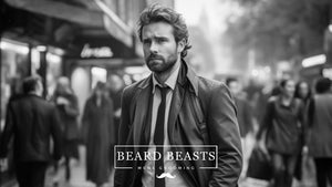 Black and white image of a well-dressed man with a beard in the awkward hair stage, looking thoughtful as he walks through a bustling city street