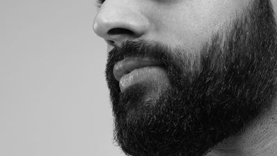 Close-up of a man's side profile showcasing a thick 3 month beard growth in black and white