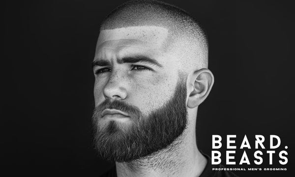 A striking black and white portrait of a confident man with a buzz cut and beard, exuding a bold and well-groomed look. 