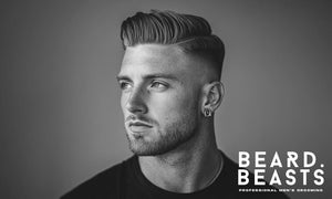Stylish young man with a sleek textured comb over haircut and a sharp fade, exuding confidence.