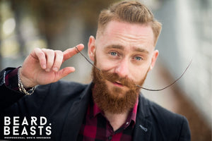  A bearded man with a styled handlebar mustache, showcasing the results of properly applying mustache wax—a perfect visual for a guide on how to apply mustache wax.