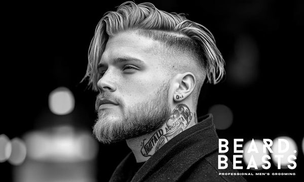 A stylish bearded man with an undercut fade hairstyle and a confident expression, captured in a high-contrast black-and-white portrait.