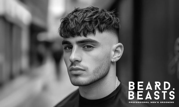 Black and white image of a man with a wavy French crop hairstyle and a high fade, showcasing natural, textured waves. 