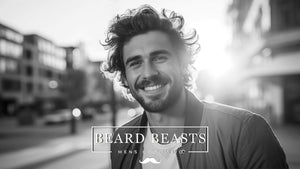 Smiling man with curly hair in an urban setting, representing Beard Beasts Men's Grooming brand, symbolizing tips on how to manage curly hair for men.
