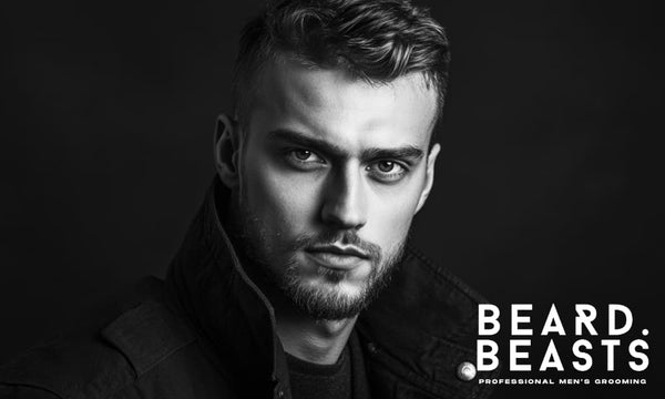 Black and white portrait of a man with short wavy hair and a well-groomed beard, styled for a bold, modern look.