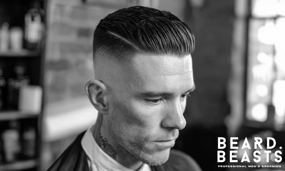 Man with a slicked back side part haircut featuring a sharp side part, clean fade, and polished finish—modern take on a classic men’s hairstyle.