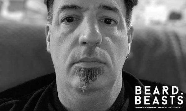 Man with a grown-out soul patch beard, seated indoors with a neutral expression—highlighting a natural, casual take on the soul patch style in 2025.
