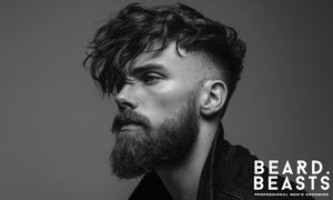 Black and white portrait of a man with an undercut and beard style, showcasing modern grooming style and contrast.