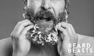 Man washing his beard with foam, visually representing what beard wash does to clean and care for facial hair.